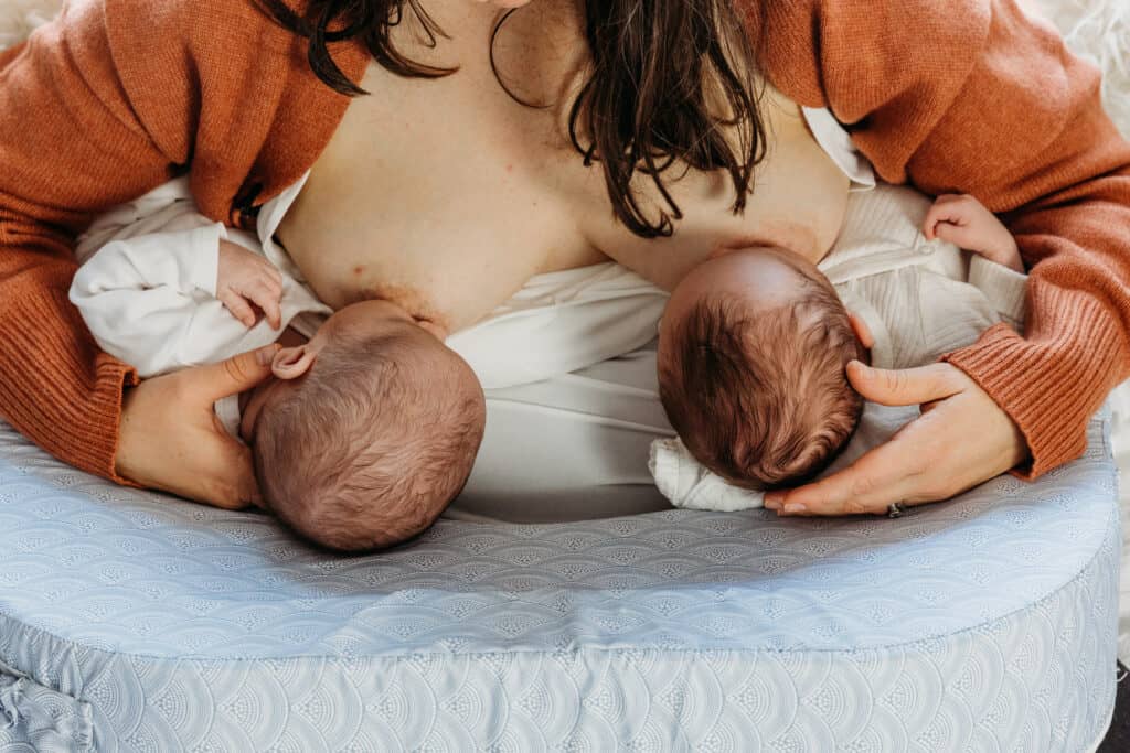 Twins in a side lay position breastfeeding