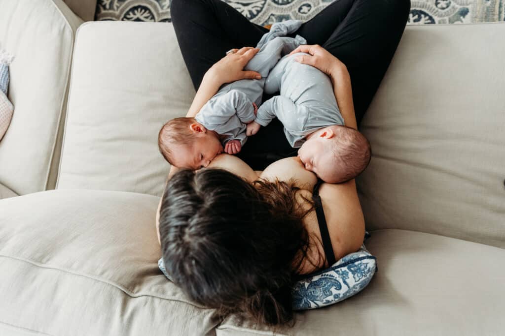 Twins breastfeeding on couch