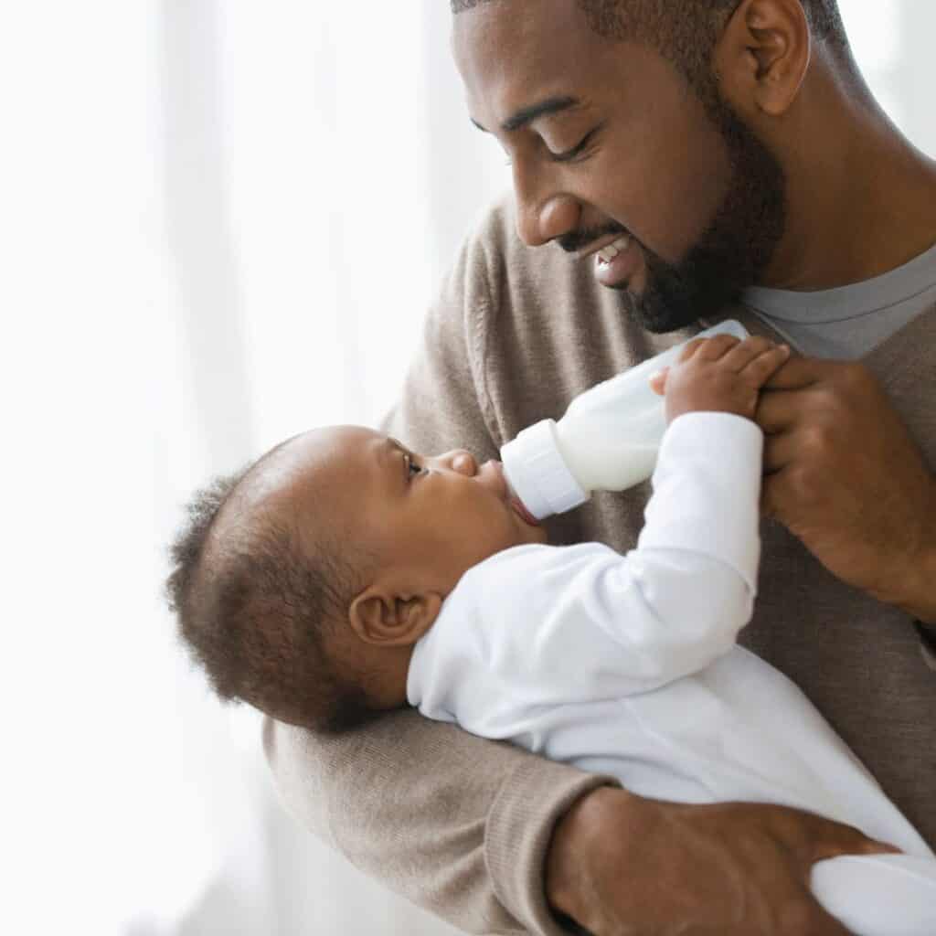Father bottle feeding baby